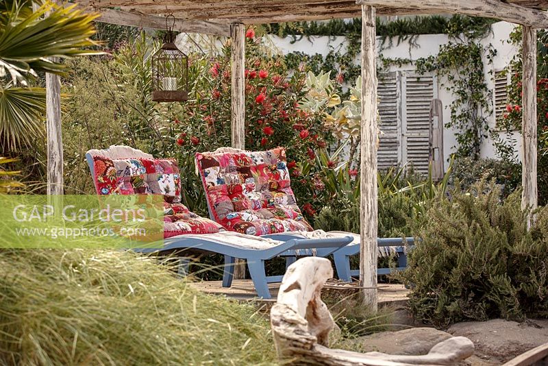 Colourful sun loungers in Mediterranean style beachside retreat with olive, pine and palm trees, 'En su Casa en la Playa - At Home on the Beach', show garden, RHS Malvern Spring Festival 2014