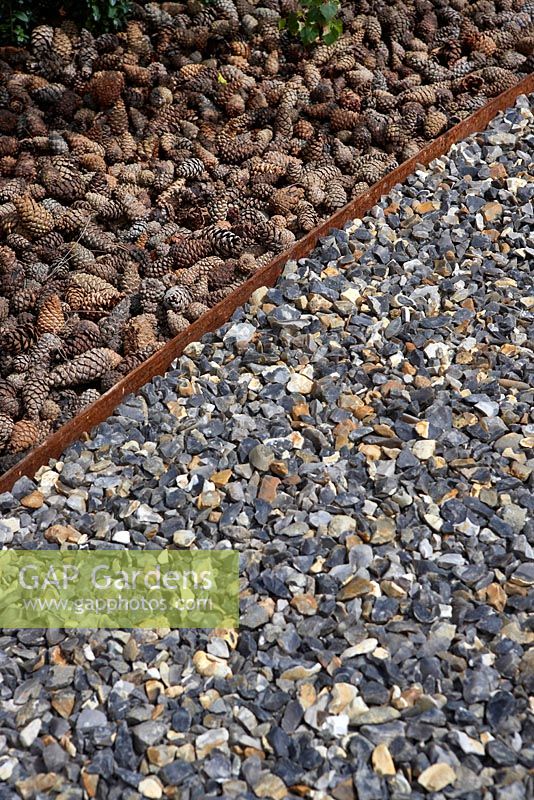 Flint gravel pathway and Fircone 'mulch' - The Flintknapper's Garden-A Story of Thetford. Designer: Luke Heydon. Sponsors: Businesses in and around Thetford - RHS Hampton Court Palace Flower Show 2014 