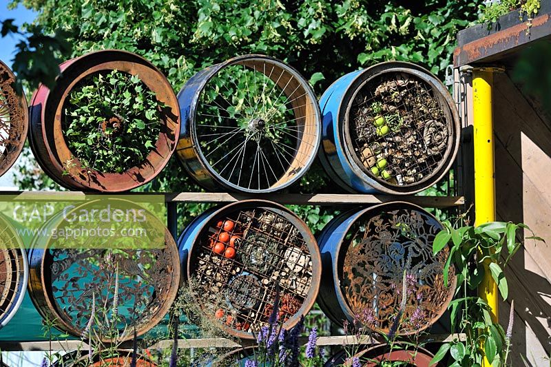 A Space To Connect and Grow. Screen using stacked decorated half cut reclaimed metal drums, wildlife wall, insect hotel

