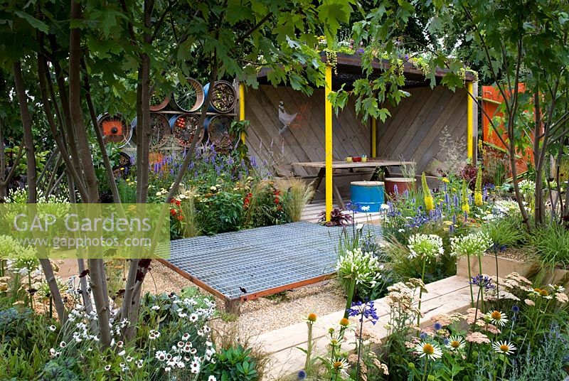 Metal A Space to Connect and Grow  View into garden with recycled mesh flooring over gravel and wooden loggia meeting space. Colourful planting with white agapanthus and echinacea and foxtail lilies. Designer: Jeni Cairns and Sophie Antonelli Sponsor: Metal Gold award best summer garden