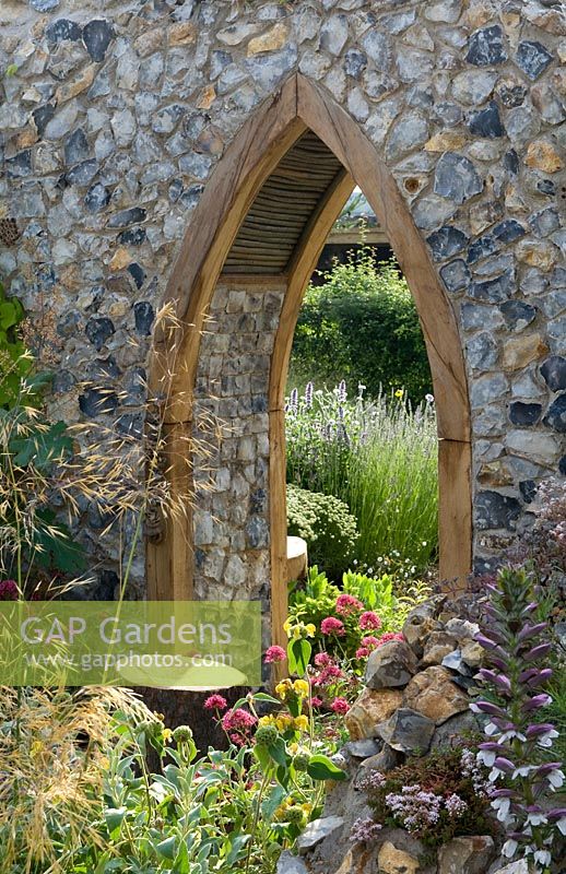 The Flintknappers garden - A story of Thetford. View glimpsed through door of ruined medieval priory church with naturalistic planting including centranthus and stipa. Designer: Luke Heydon Sponsor: Thetford business community Silver-gilt award  