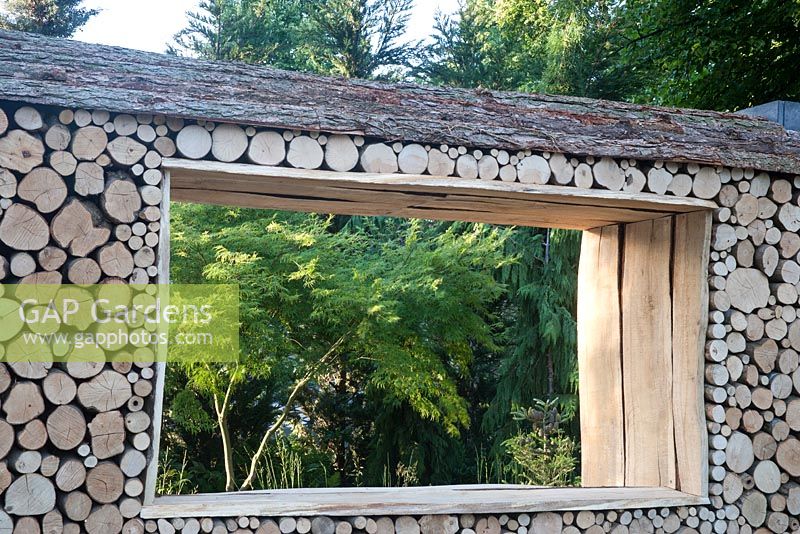 Green is the Colour - view of log wall and insect bug houses hotel - Designer - Elinor Scarth and Etienne Haller - Sponsor - The RHS