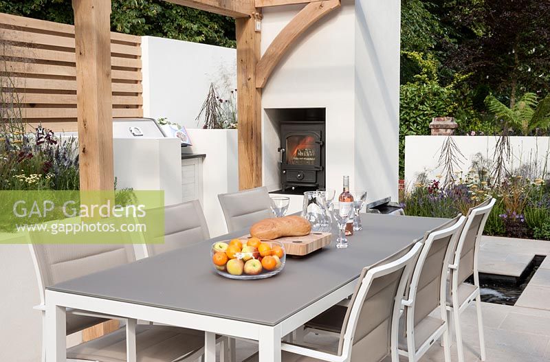 Al Fresco - view of contemporary outdoor living area patio with tables and chairs outdoor wood burning stove - Designer -  Peter Reader - Sponsor - Living Landscapes