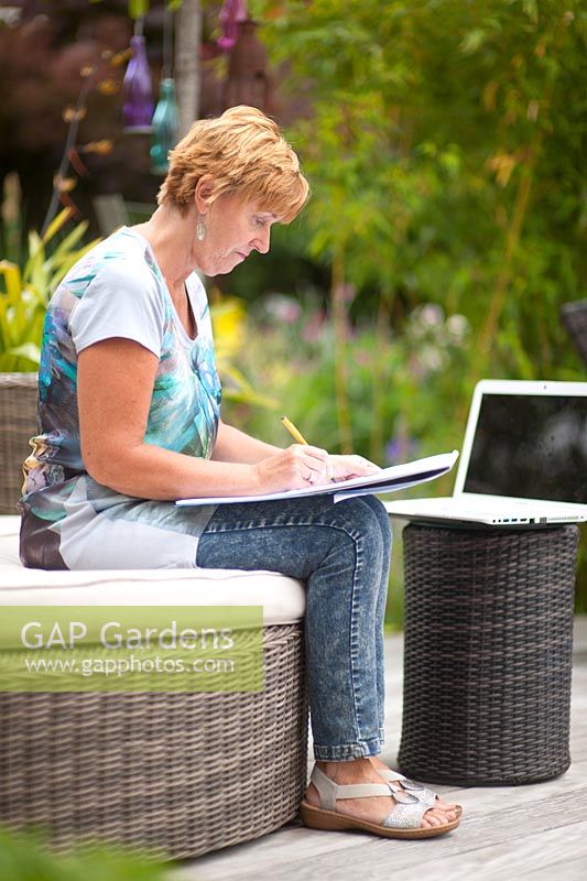 Garden designer, Angie Barker sketching in her garden 