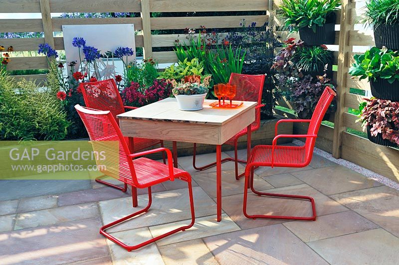 Table and chairs in Patio garden, with raised timber beds and timber fencing. Description: The Narrows Garden, Designer: Phillippa Probert, Sponsor: Beers Building Supplies 