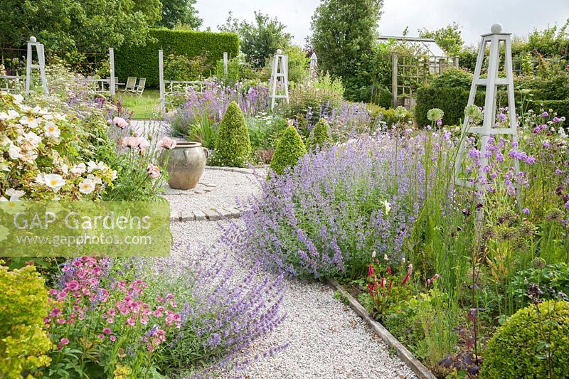 A flower garden of perennials wooden obelisks providing year round structure. 