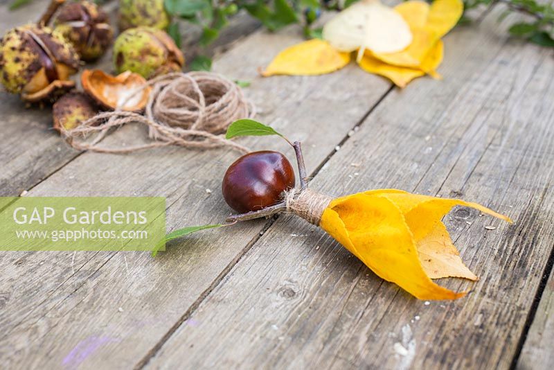 Conker Fairy. Materials used are Aesculus hippocastanum - Conkers, Jute twine, autumnal leaves and a Prunus cutting. 