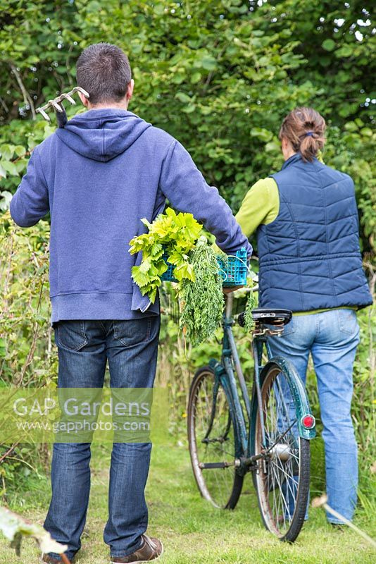 Man and woman leaving an allotment carrying their produce with them