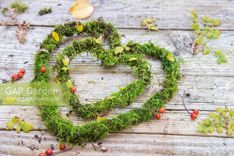 Christmas heart decorations made from moss, against a wooden backdrop.