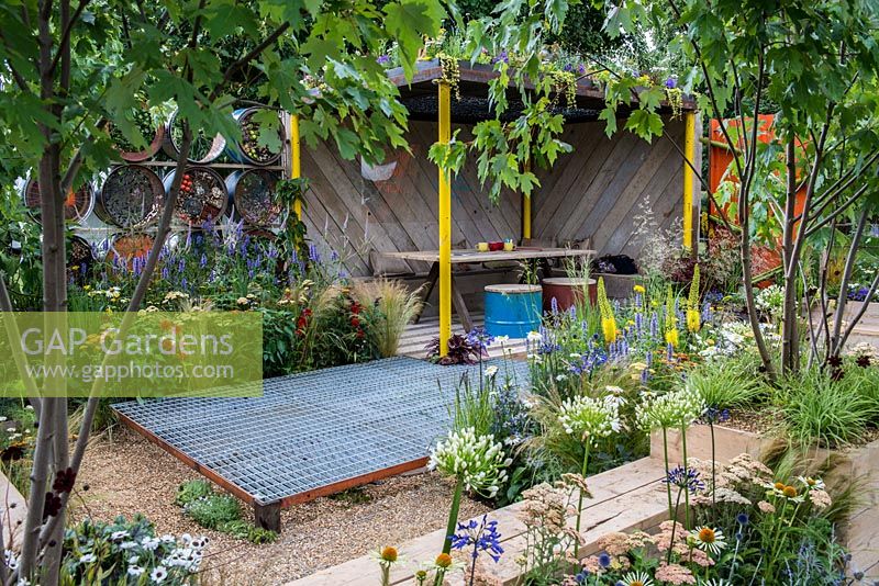 A contemporary garden created from reclaimed and salvaged materials with a covered seating area and green roof.