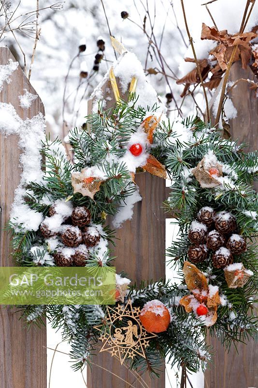 Christmas wreath attached to a fence.