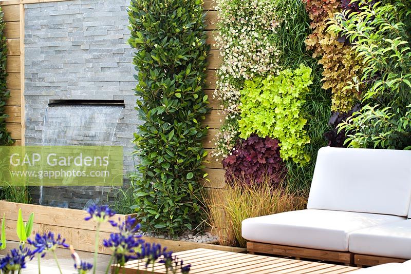 Chairs with cushions on decking. RHS Hampton Court Flower Show 2014, Design: Ian Hammond