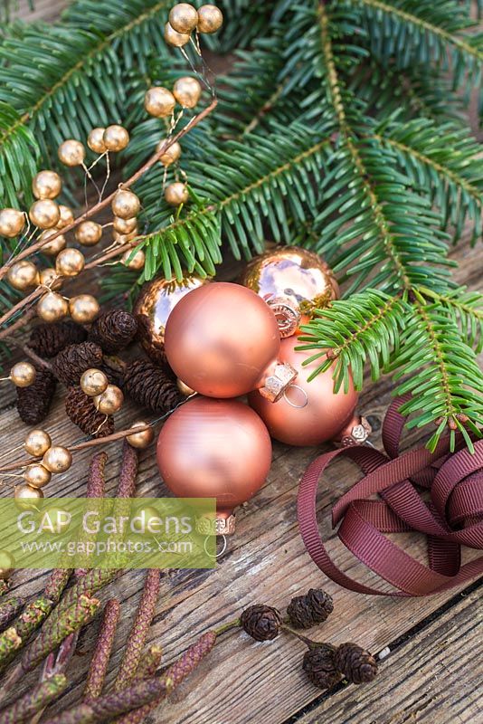 Copper colour themed Christmas decorations. Baubles, ribbon, alder foliage and yew tree foliage