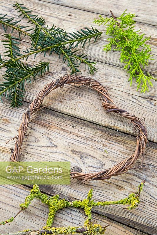 Twined heart wreath made from vines, with foliage of Conifer and Prunus with lichen