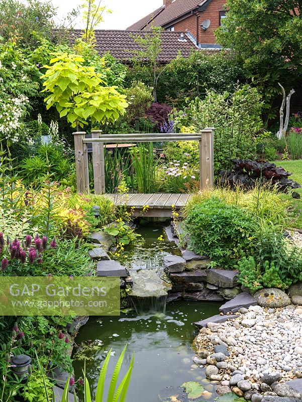 16m square back garden with gravel and boggy areas, wildlife pond, bridge and stream.
