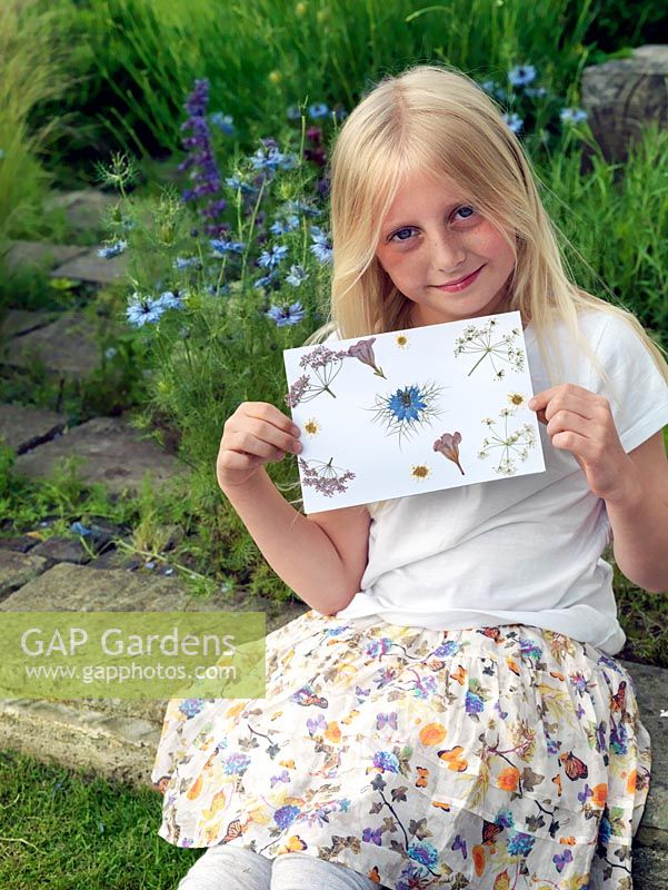 The garden flowers that this little girl picked two weeks before are now dry, and ready to make into a Mother's Day card.