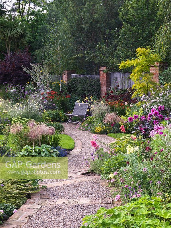 Beds of lychnis, nicotiana, Alstroemeria Spitfire, Verbena bonariensis, bidens, Lavatera Barnsley, allium, onopordum, cercis, robinia, dahlia, sedum, lavender, achillea.