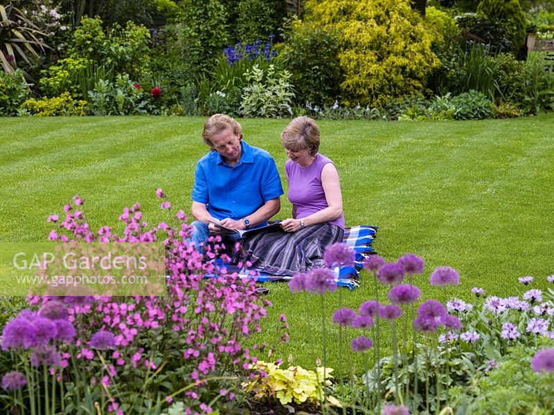 Terry Bartholomew and Margaret Arnott sit on the lawn of their garden