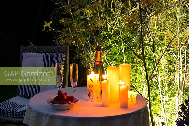 Romantic drinks by candlelight in the garden at night