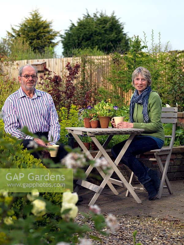 John and Corinne Layton relaxing in their quarter acre garden overlooking fields.