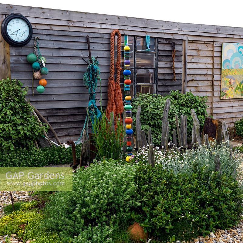 Shed decorated with floats and rope found on beachcombing walks behind island bed of silene and Helichrysum italicum. Totem pole made by local ceramicist Lynne Waylen.