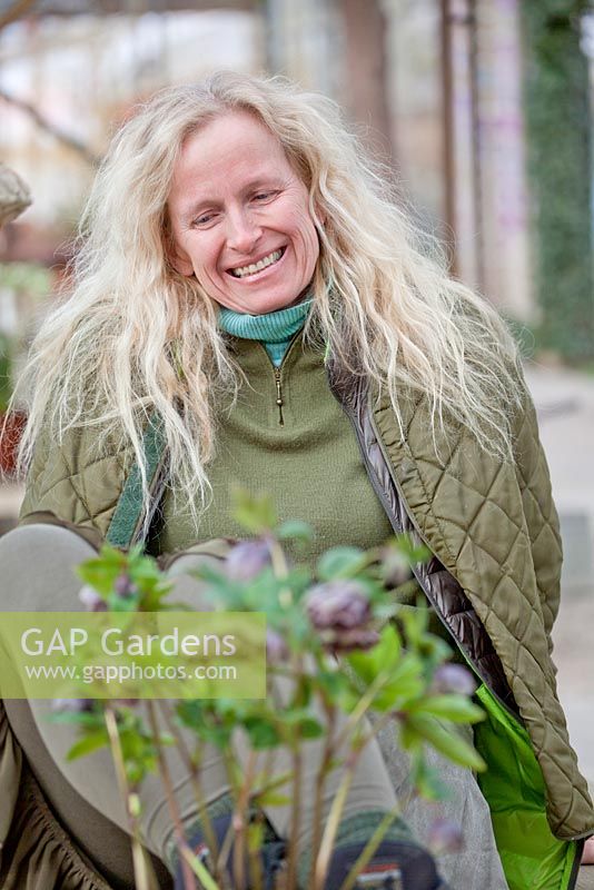 Nelli Haasakker sitting on table with Helleborus in pot.