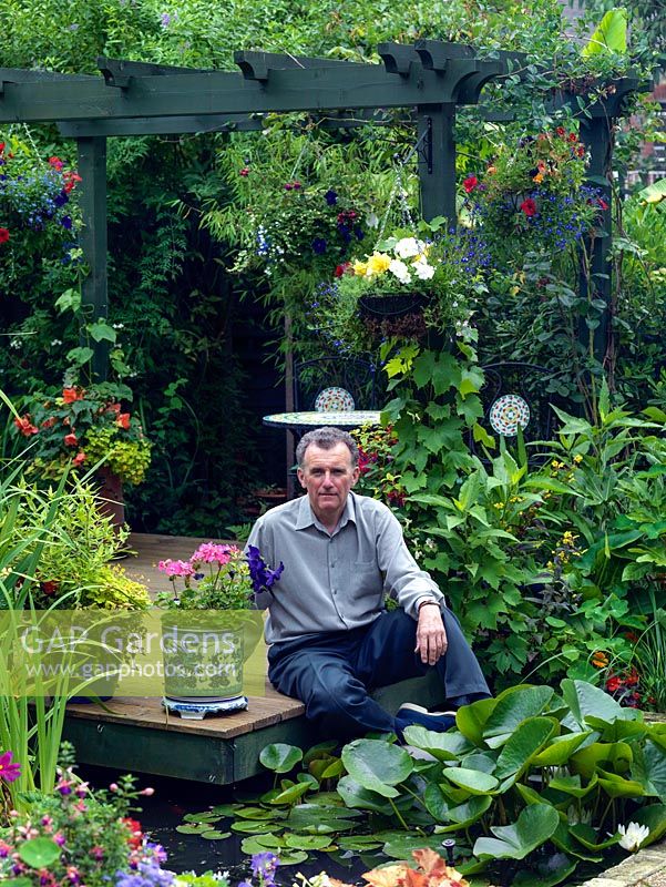 Brian Bowles in his garden Redston Road. On a small sloping plot it is designed on the diagonal to maximise the appearance of width.