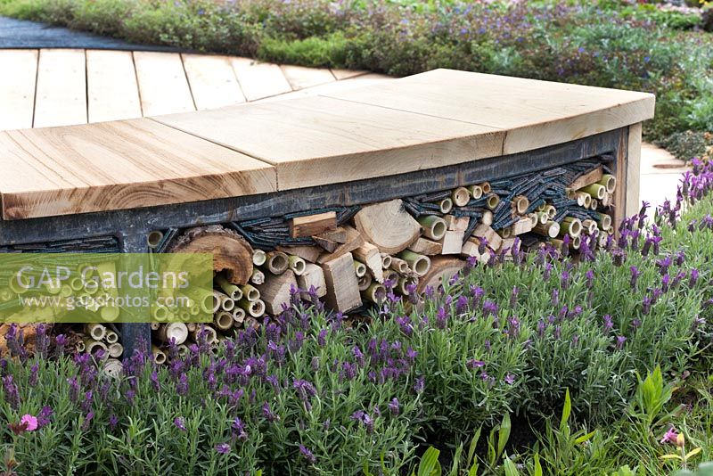 Curved wooden seat with integrated wildlife hotel, bordered with lavender. The Journey Garden, supported by St Michael's Hospice, Malvern Spring Gardening Show 2015.