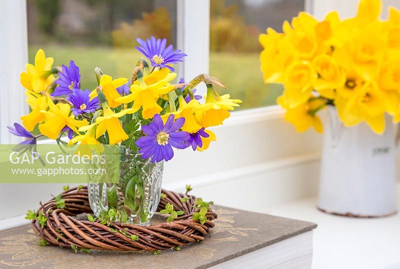 Narcissus and Anemone in a glass jar within woven willow wreath