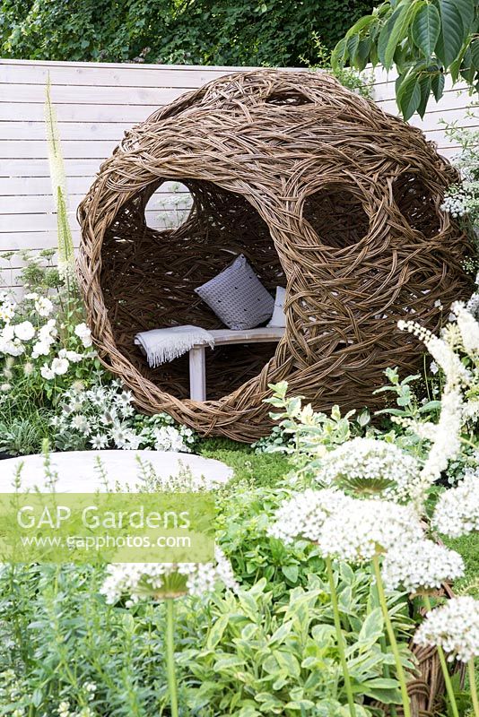 Spherical willow bird hide with bench, white Allium in foreground - Living Landscapes: City Twitchers Garden, RHS Hampton Court Palace Flower Show 2015