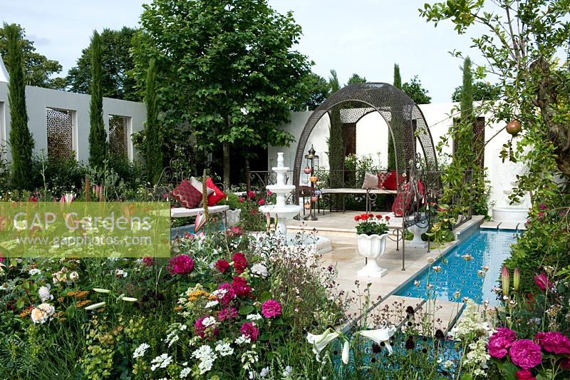 Turkish Ministry of Culture and Tourism. Garden of Paradise Islamic garden with traditional elements, strong geometric architecture,pavilion, fountain, water rills, hard landscaping with mixed perennial borders, seating. Plane tree, cypresses and a pomegranate tree - RHS Hampton Court Palace Flower Show 2015