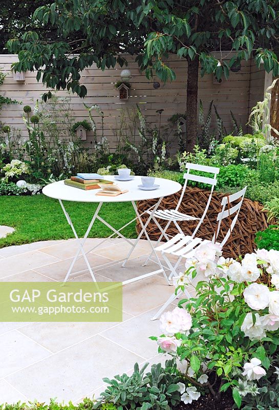 Circular seating area surrounded by a chamomile lawn, with bistro table and chairs - Living Landscapes 'City Twitchers', RHS Hampton Court Flower Show 2015