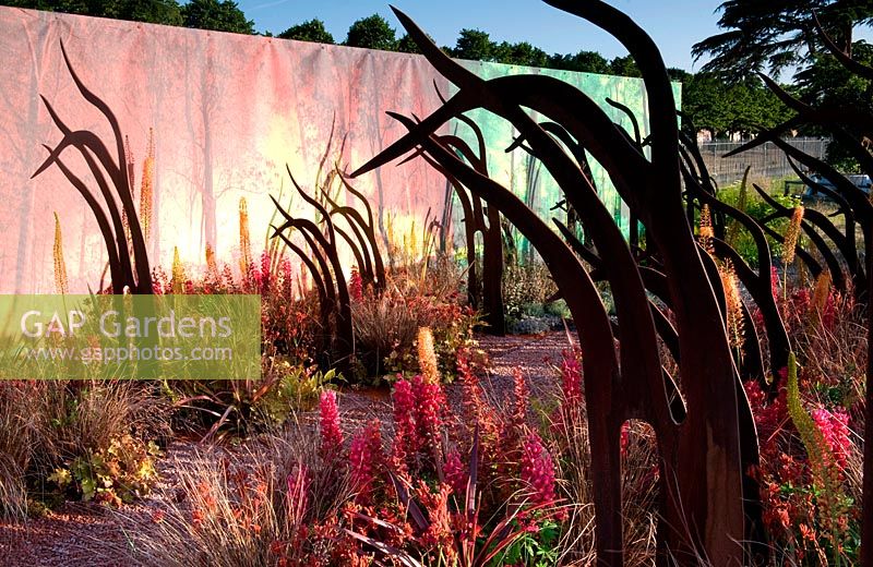 Best Conceptual Garden - Desolation to Regeneration. RHS Hampton Court Palace Flower Show 2013. Gold Medal. Corten steel sculptures resemble burned trees. Design: Catherine MacDonald 