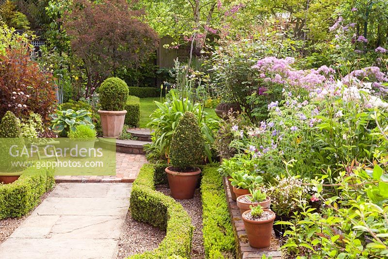 Looking across the parterre towards the sunny herbaceous border. Hope House, Caistor, Lincolnshire, UK. 