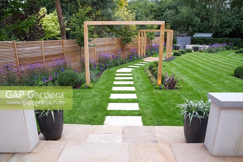 View from patio looking down the path leading to the pergola and sunken seating area