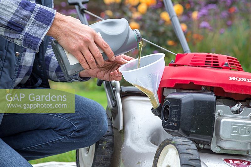 Whilst the lawn mower is upright, use a funnel to fill the lawn mower with new engine oil