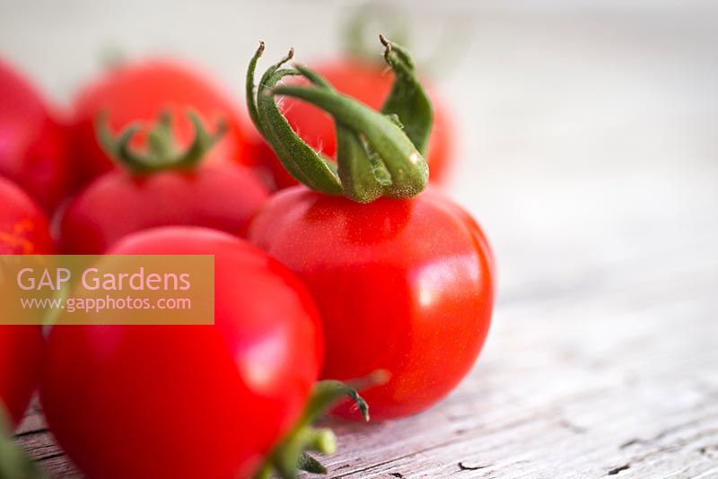 Tomato 'Gardener's Delight' on wooden surface