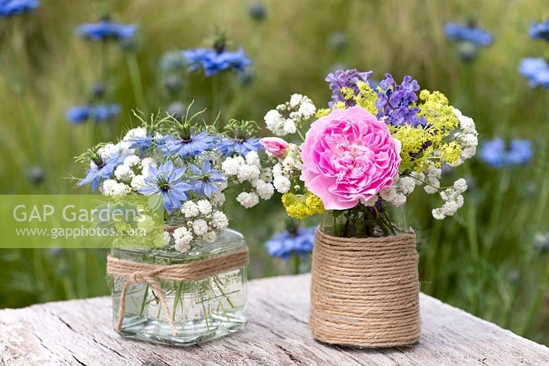 Summer cut flowers in glass jars decorated with twine.