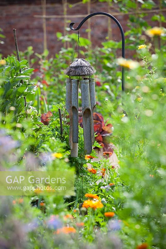 Wind chime used as bird scarer in a vegetable garden to protect crops in a vegetable garden