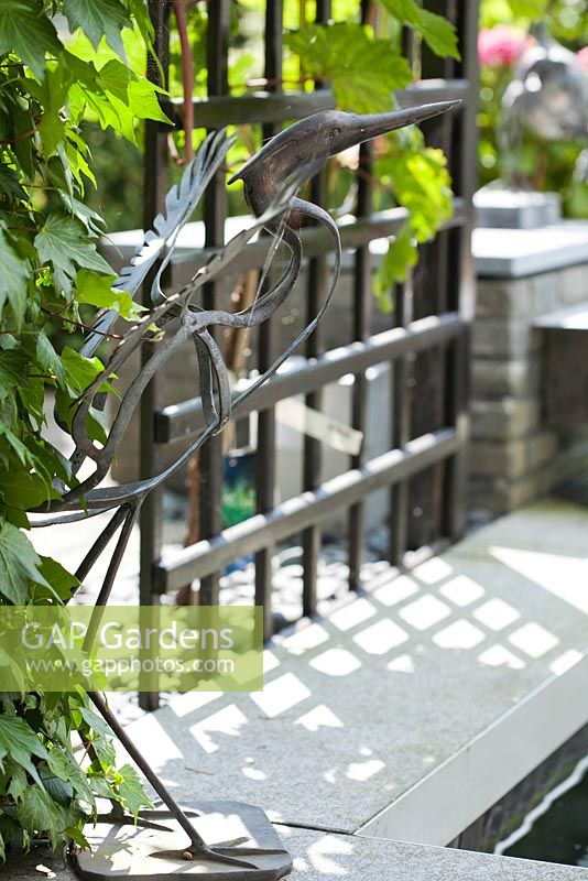 Iron Heron near the pond. Trellis with climbing grape. Family Fabry - Mathijs. Belgium