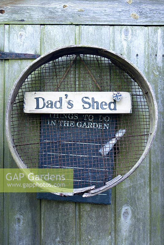 Vintage garden sieve hanging on shed door with Dad's Shed sign and Union Jack heart. June