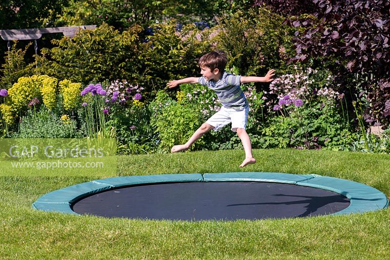 7-year-old Archie on the trampoline, set into the lawn.
