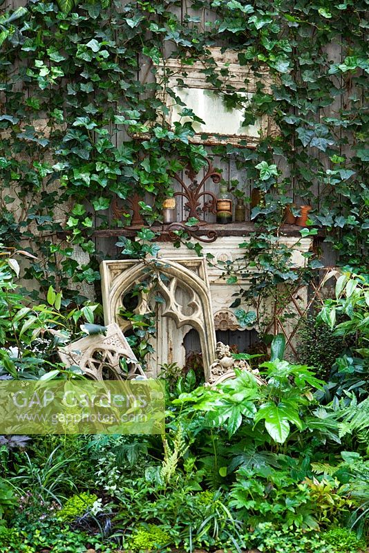 View of border in court yard garden with fire place. Hedera helix, Fatsia japonica and Asplenium scolopendrium, Lucille Lewins, small office court yard garden in Chiltern street studios, London. Designed by Adam Woolcott and Jonathan Smith