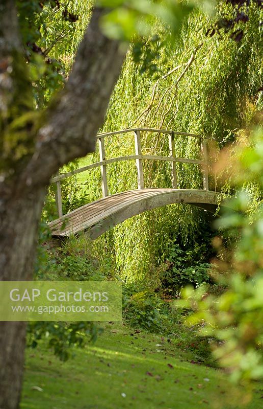Walled garden, Cambo, Fife, Scotland, UK. Arched bridge over burn