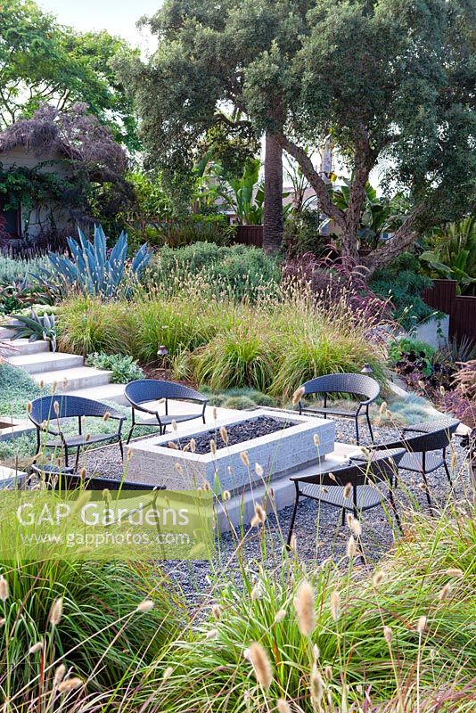 View of gas fired fire pit and outside seating. Debora Carl's garden, Encinitas, California, USA. 