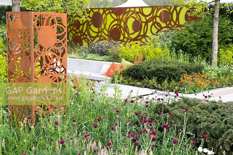 Decorative panels by Natasha Webb, surrounded by Tiarella cordifolia, Taxus baccata, Cirsium rivulare 'Atropurpurea',  The Sunken Retreat, RHS Malvern Spring Festival 2016
