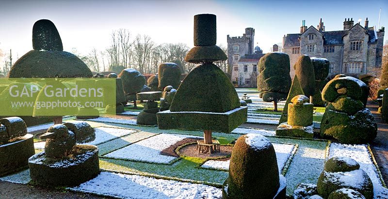 View of house and garden with snow on the ground. Levens Hall and Garden, Cumbria, UK.