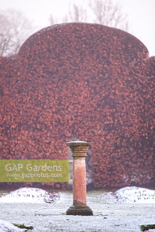 Stone sun dial infront of a Beech hedge at Levens Hall and Garden, Cumbria, UK