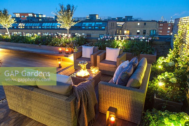 Outside seating area on a London roof terrace at night with candles and outside lighting.  April. 