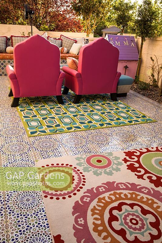 Patio with mosaic tiling, colourful rugs and furniture